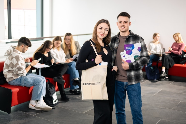 Młoda para z materiałami informacyjnymi PANS w holu uczelni