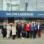 Grupa osób przed budynkiem Excellent S.A. - salon łazienek