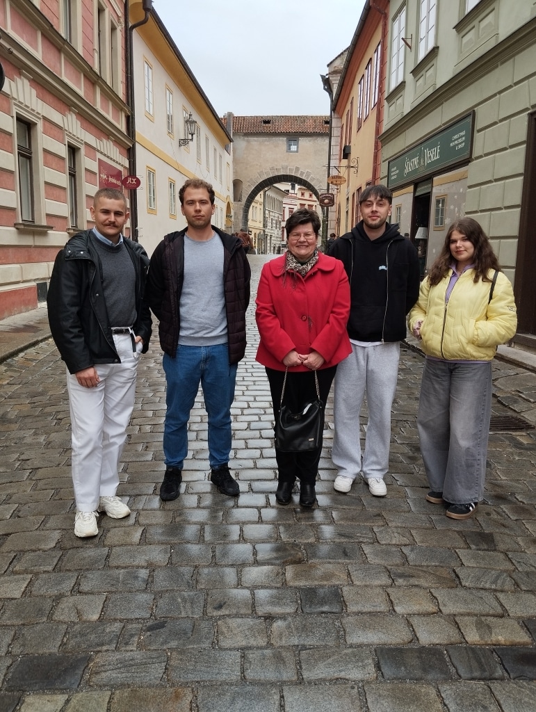 Studenci zarządzania z Czeskich Budziejowic na brukowanej ulicy w Pradze.