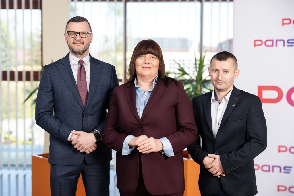Trzech profesjonalistów z firmy Pansco w garniturach, stojących w biurze.