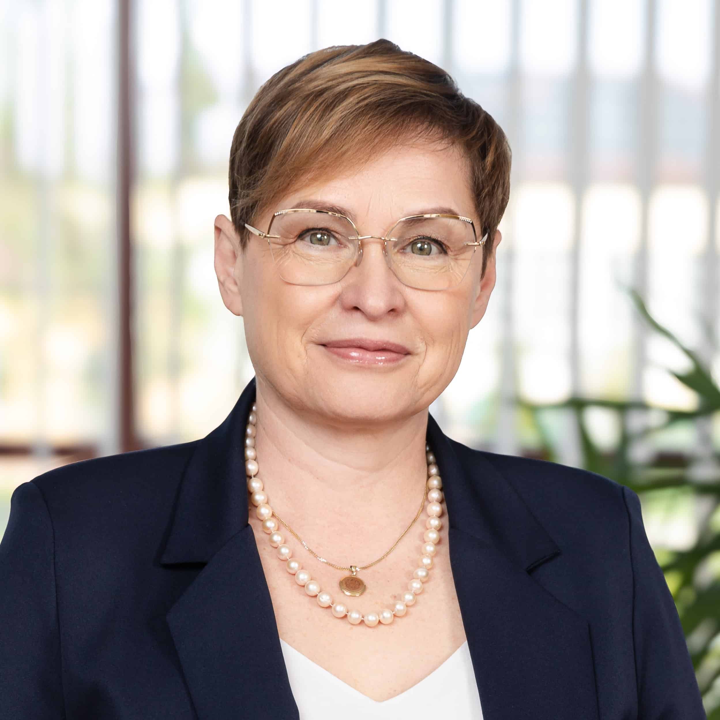 Portret biznesowy kobiety w okularach i perłach