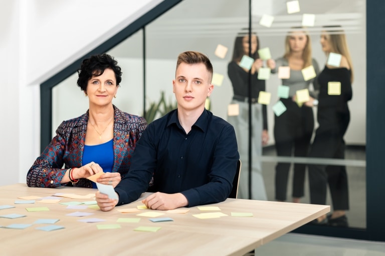 Zespół pracuje nad zarządzaniem projektami, używając karteczek samoprzylepnych.