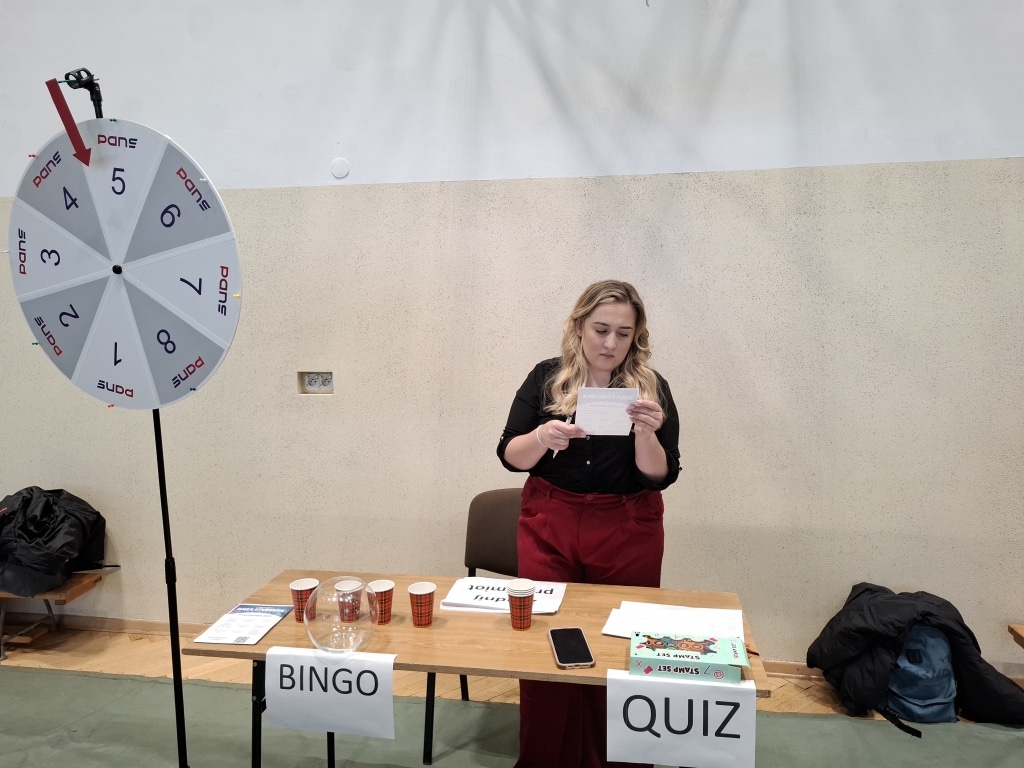 Kobieta z kartką przy kole fortuny na Dniu Studenta