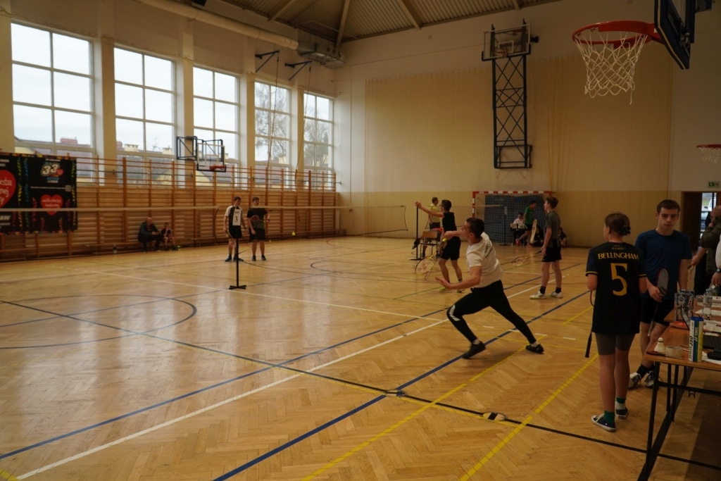 Turniej badmintona dla WOŚP: młodzi gracze na boisku w hali sportowej