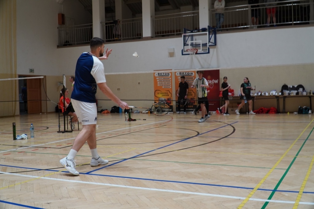 Mężczyzna grający w badmintona podczas turnieju WOŚP w hali sportowej.