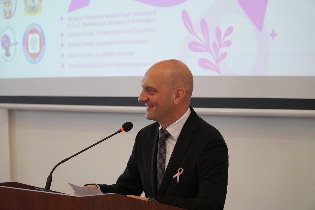 Mężczyzna w garniturze przemawia na sympozjum Różowy Październik