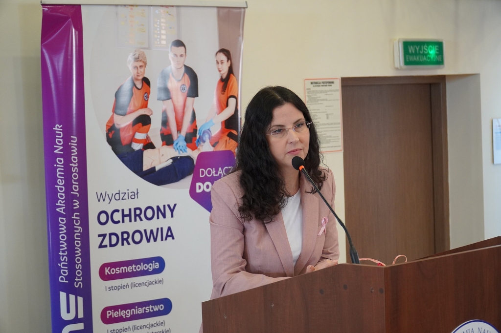 Sympozjum Różowy Październik: przemawia kobieta w różowej marynarce