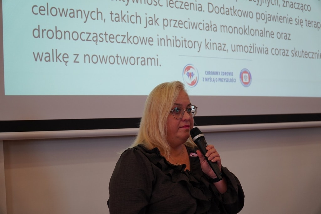Kobieta z mikrofonem na sympozjum Różowy Październik