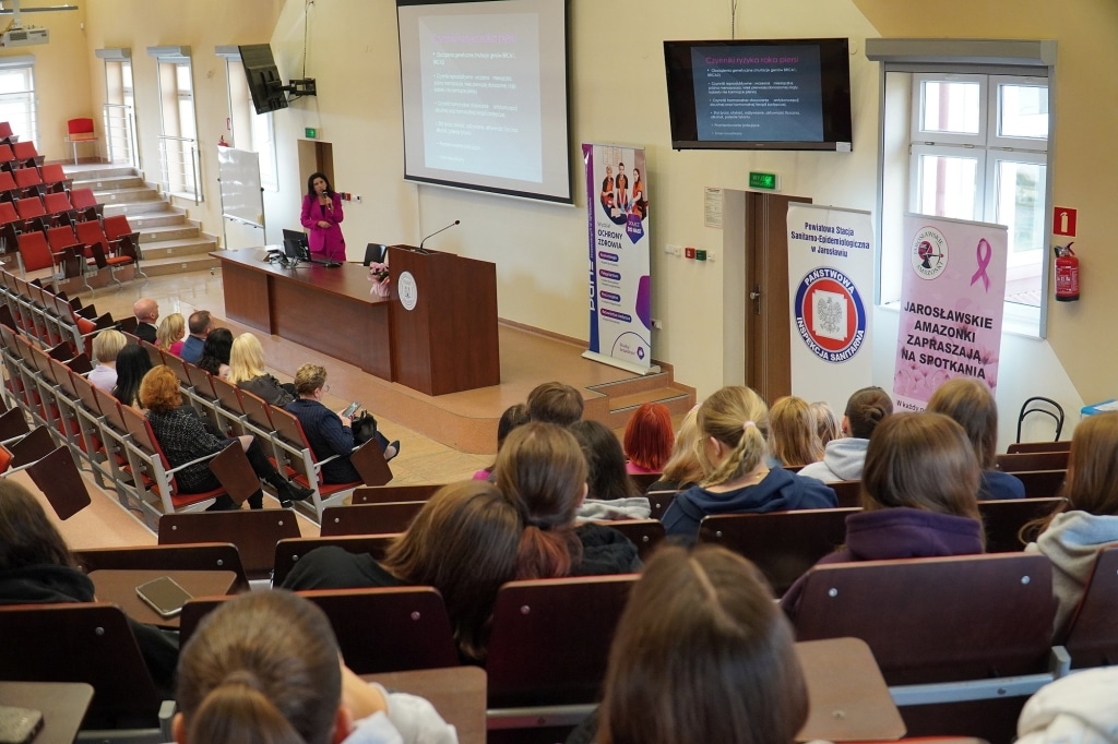 Sympozjum Różowego Października: prelegentka i słuchaczki w sali wykładowej.
