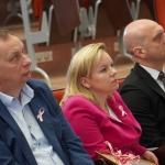 Uczestnicy sympozjum naukowego "Różowy Październik" z różowymi wstążkami.