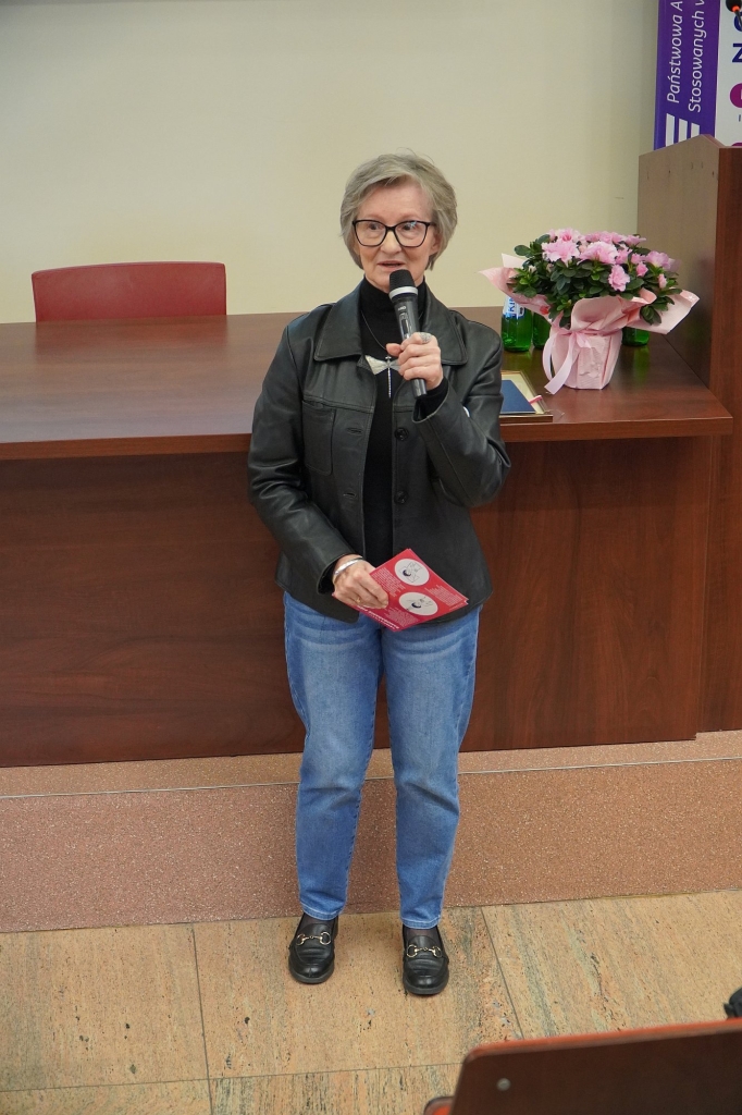 Kobieta z mikrofonem i broszurą na sympozjum Różowy Październik