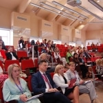 Uczestnicy konferencji „Innowacje pedagogiczne w wychowaniu przedszkolnym” siedzą na widowni.