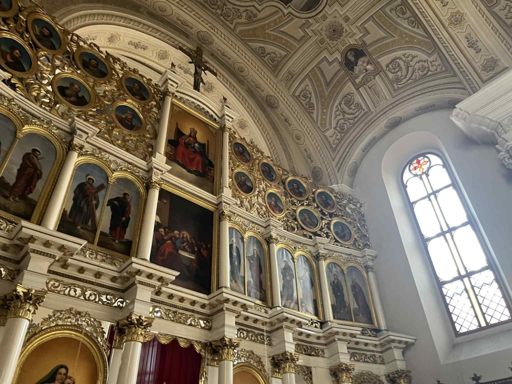 Wnętrze cerkwi z ikonostasem i oknem witrażowym