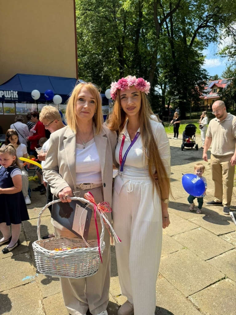 Dwie kobiety na pikniku rodzinnym, jedna z wiankiem na głowie.