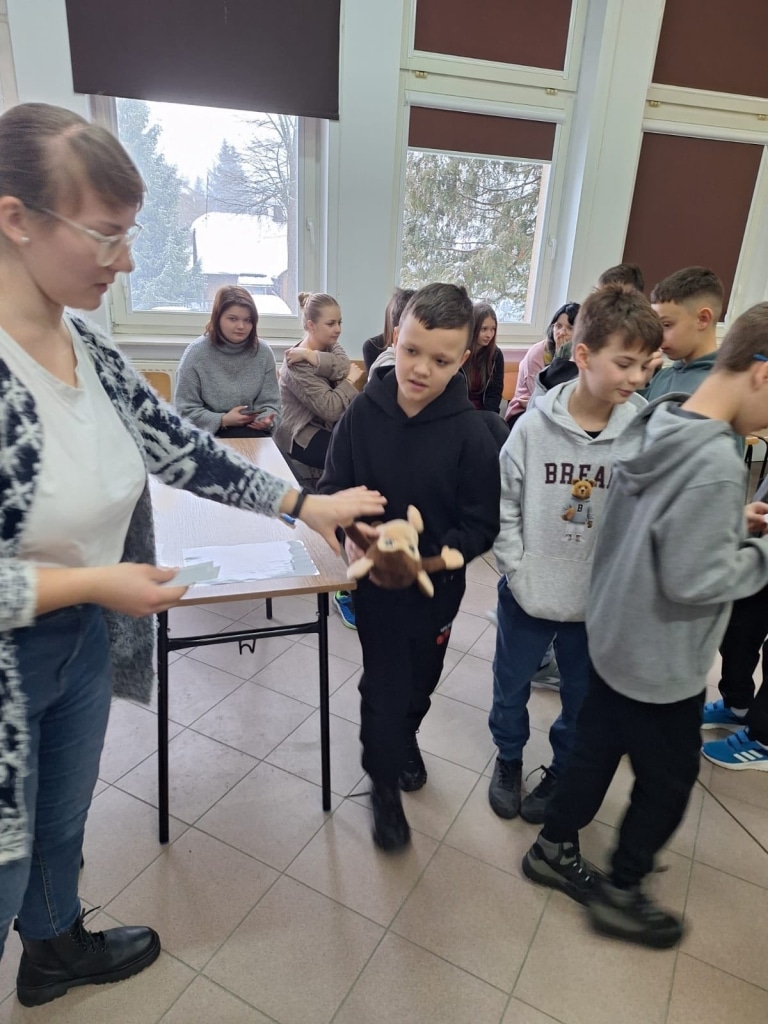 Dzieci na Przyrodniczym Uniwersytecie Dzieci odbierają pluszowe zabawki.