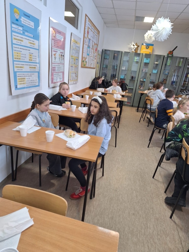 Dzieci jedzą posiłek podczas spotkania Przyrodniczego Uniwersytetu Dzieci.
