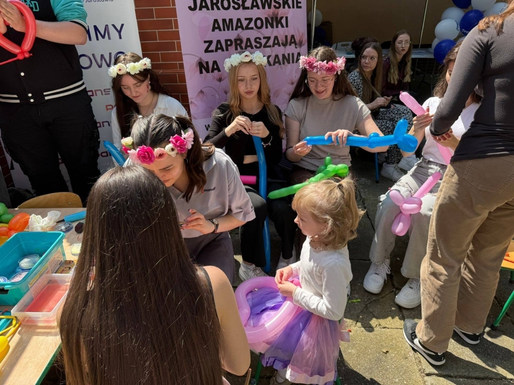 Dzieci na pikniku rodzinnym tworzą balony z pomponów