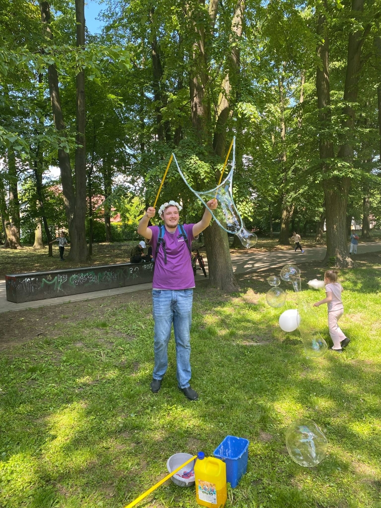 Mężczyzna robi bańki mydlane w parku podczas pikniku rodzinnego.