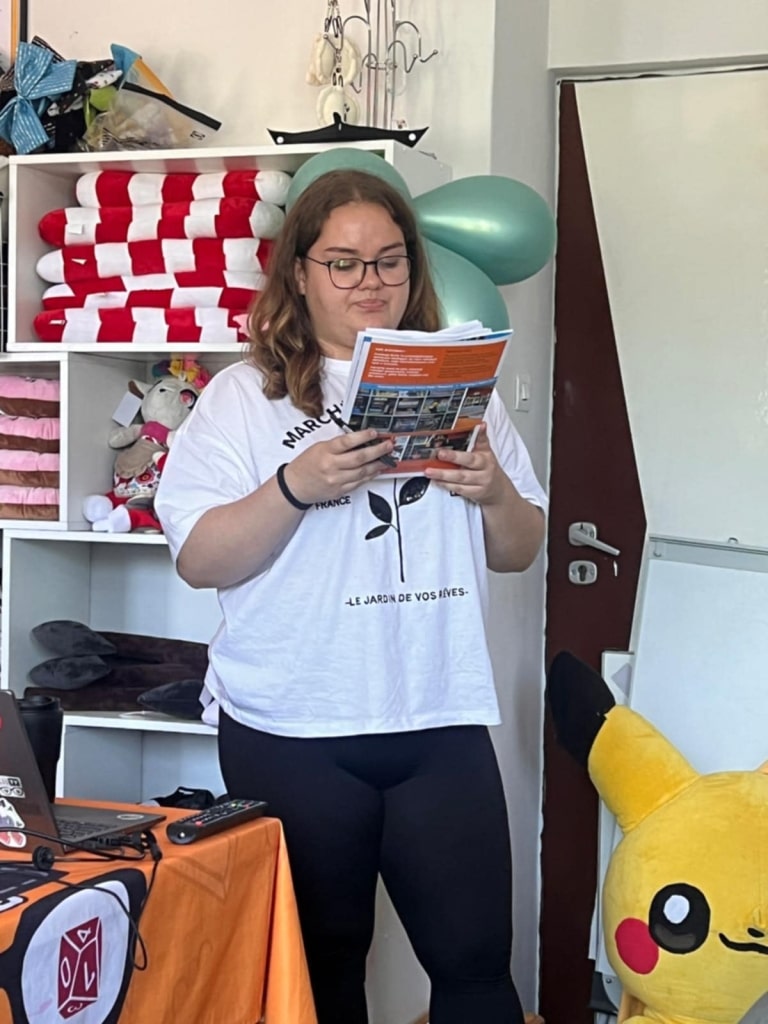 Kobieta czyta materiały na warsztatach storytellingu, z Pikachu w tle.