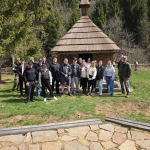 Grupa osób przed kapliczką w lesie podczas wizyty studyjnej Straży Granicznej