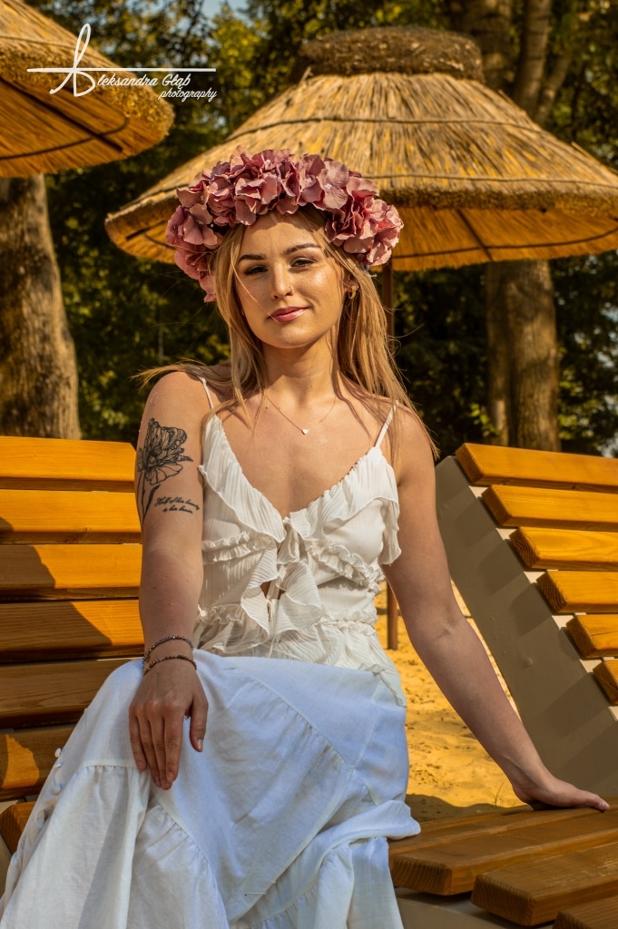 Młoda kobieta w wianku z kwiatów na plaży podczas sesji "Żyj słońcem, kochaj księżycem