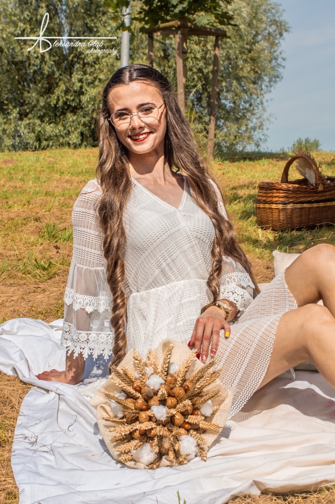 Młoda kobieta w białej sukience z bukietem zbóż i bawełny, sesja zdjęciowa „Żyj słońcem, kochaj księżycem”