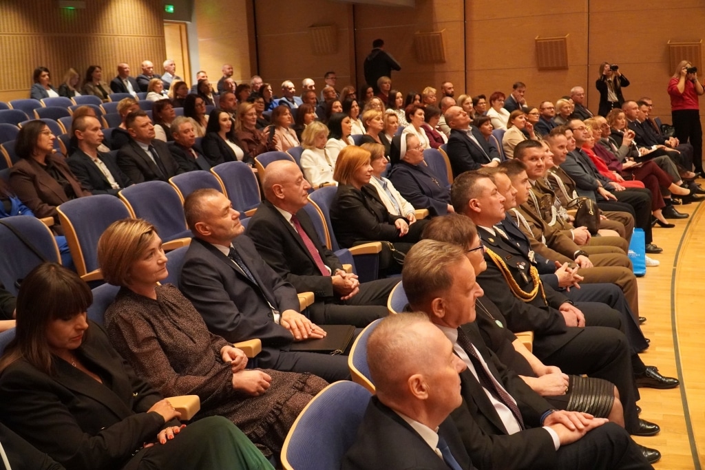 Uczestnicy Dnia Edukacji Narodowej siedzą na widowni w sali.