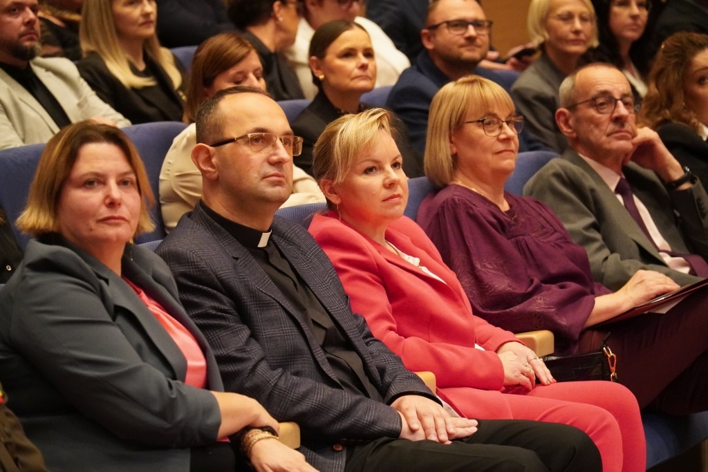 Uczestnicy Dnia Edukacji Narodowej siedzą w sali.