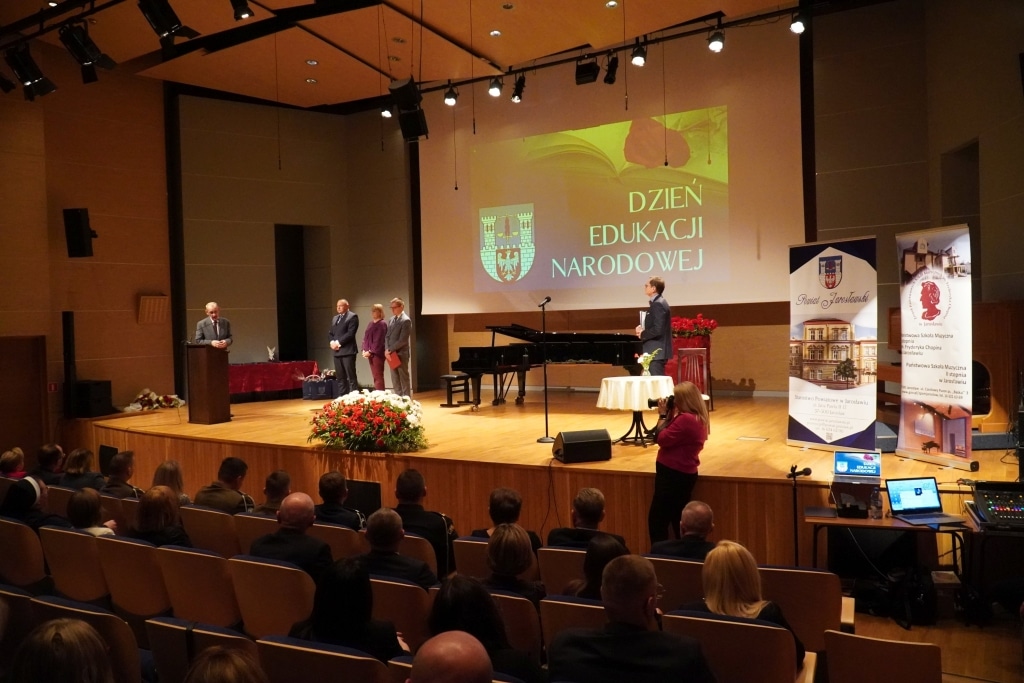 Uroczystość z okazji Dnia Edukacji Narodowej na scenie z ekranem