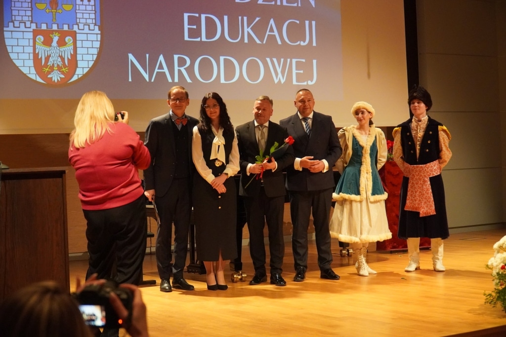 Uroczystość Dnia Edukacji Narodowej: nauczyciele i uczniowie na scenie.