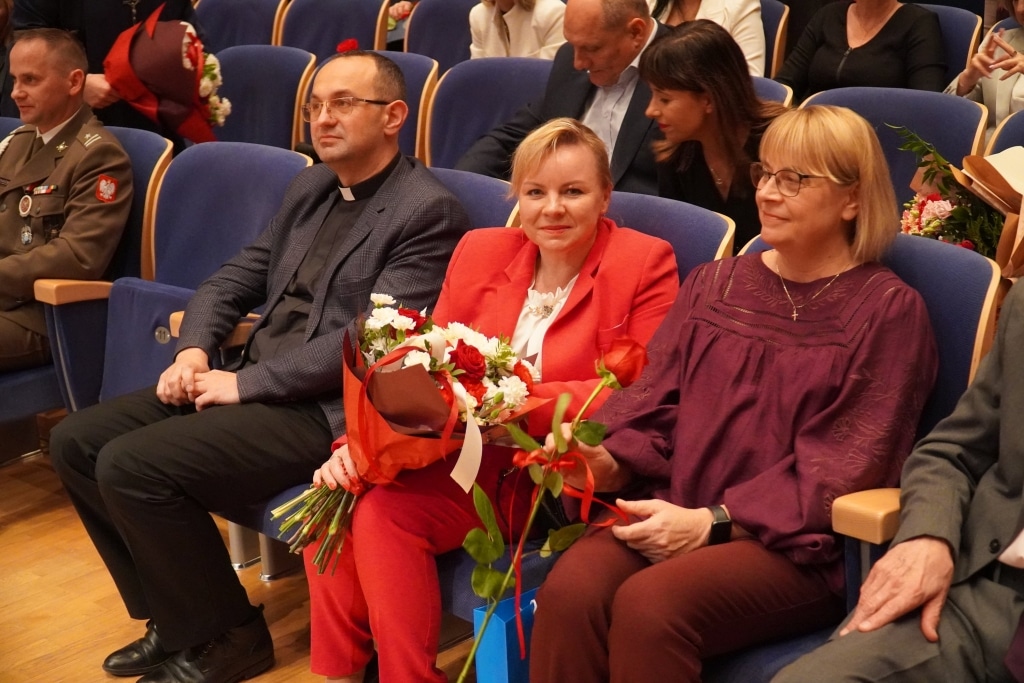 Dzień Edukacji Narodowej: Uczestnicy w sali, z bukietami kwiatów