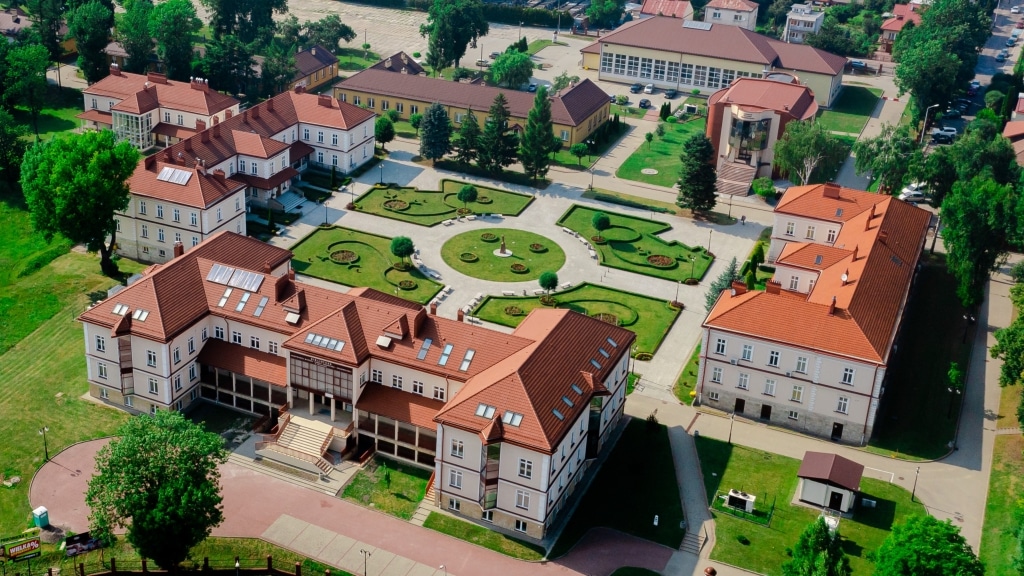 Widok z lotu ptaka na kampus z budynkami i zielenią, miejsce konferencji "Bezpieczeństwo informacyjne w zarządzaniu kryzysowym