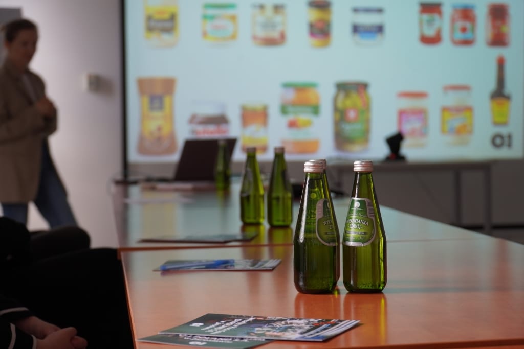 Wizyta studyjna w Hucie Szkła O-I: butelki wody na stole konferencyjnym