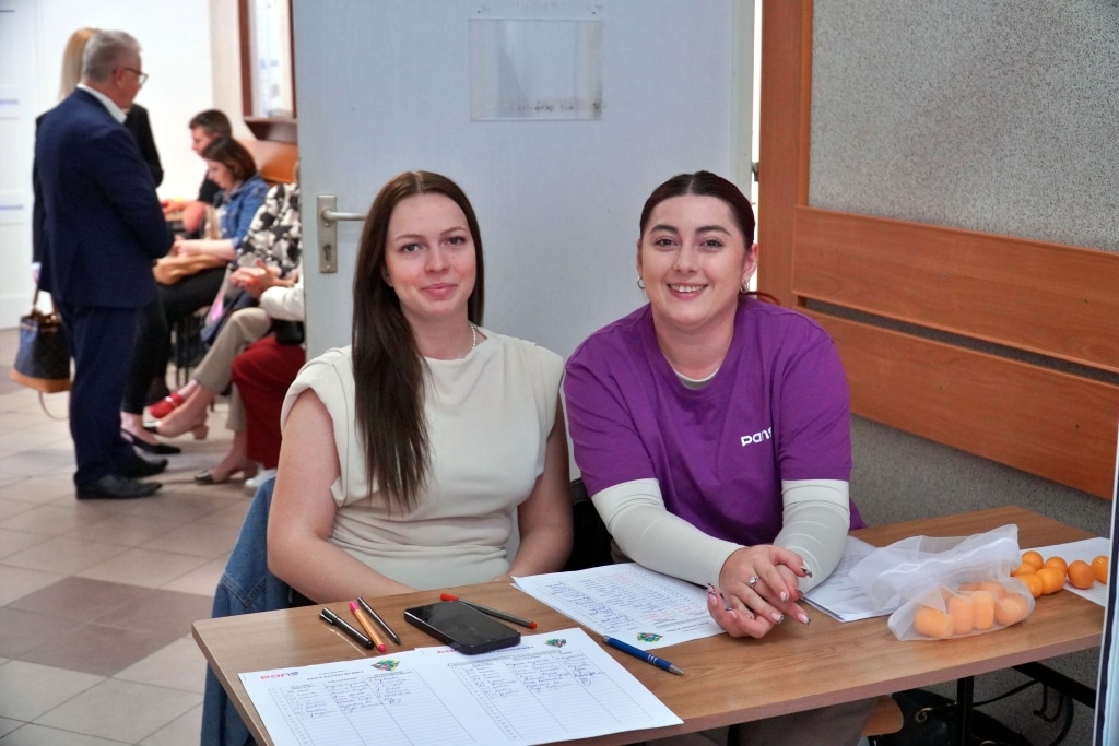 Kobiety przy punkcie informacyjnym Dnia Jakości Pedagogiki Przedszkolnej.