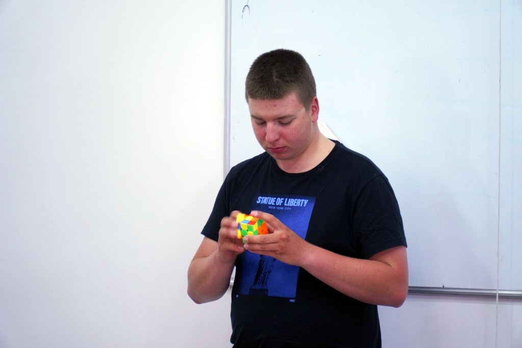 Student rozwiązuje kostkę Rubika na Dniu Jakości Pedagogiki Przedszkolnej.