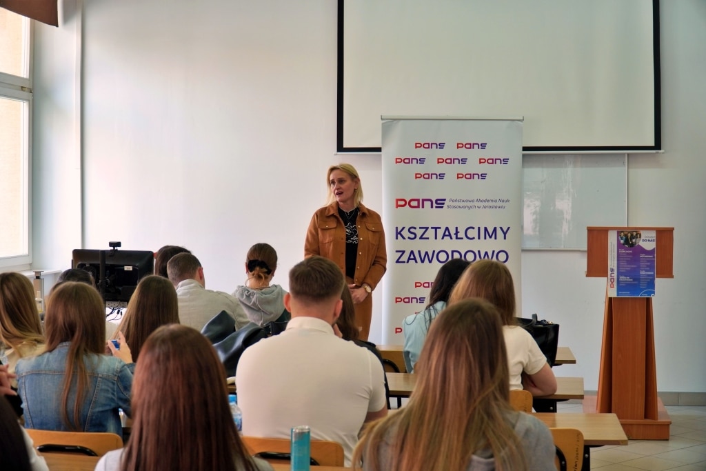 Kobieta przemawia do studentów pedagogiki na Dniu Jakości
