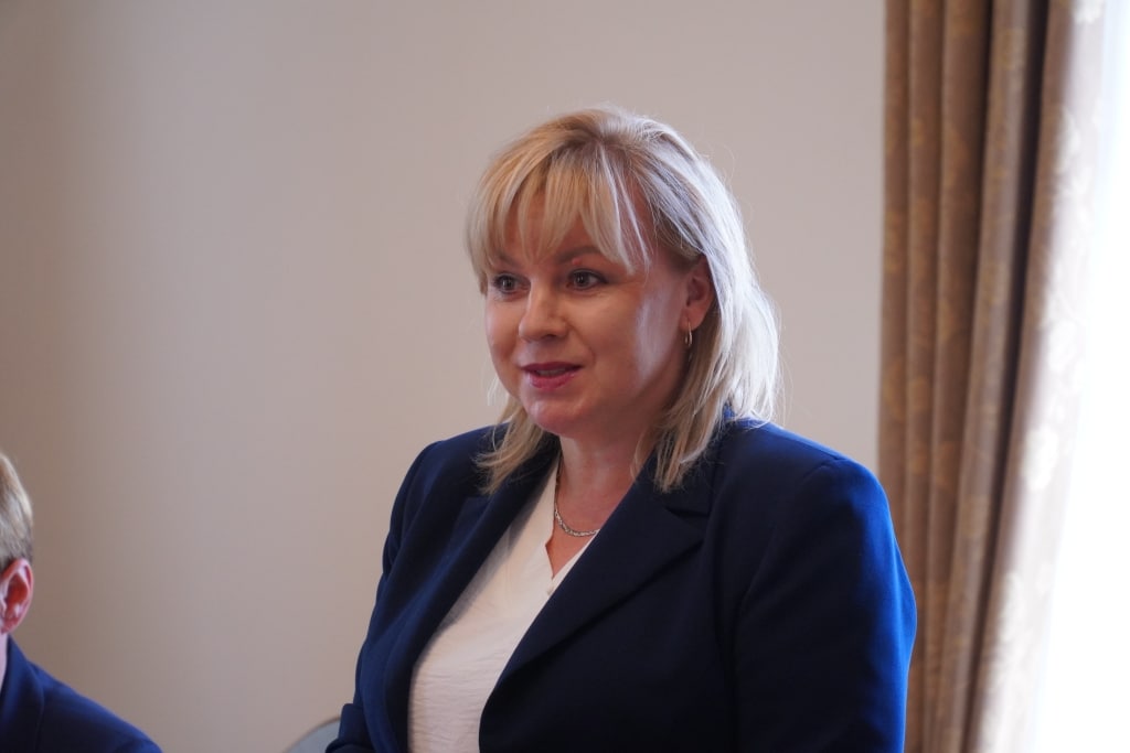 Kobieta w marynarce na spotkaniu podsumowującym rok akademicki