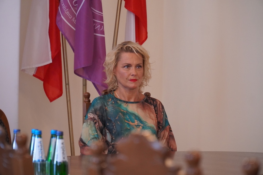 Kobieta siedzi przy stole podczas podpisania porozumień o współpracy z jarosławskimi placówkami.