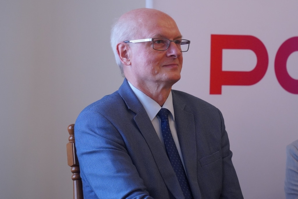 Mężczyzna w garniturze i okularach podczas podpisania porozumień z jarosławskimi placówkami.