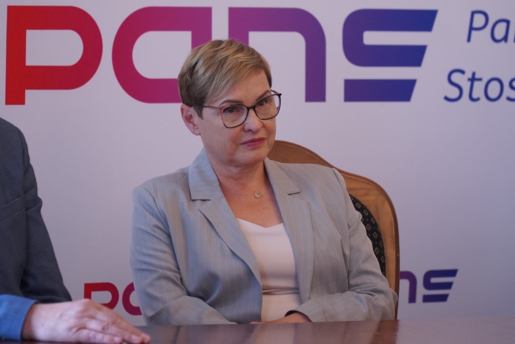 Kobieta w jasnej marynarce podczas podpisania porozumień o współpracy