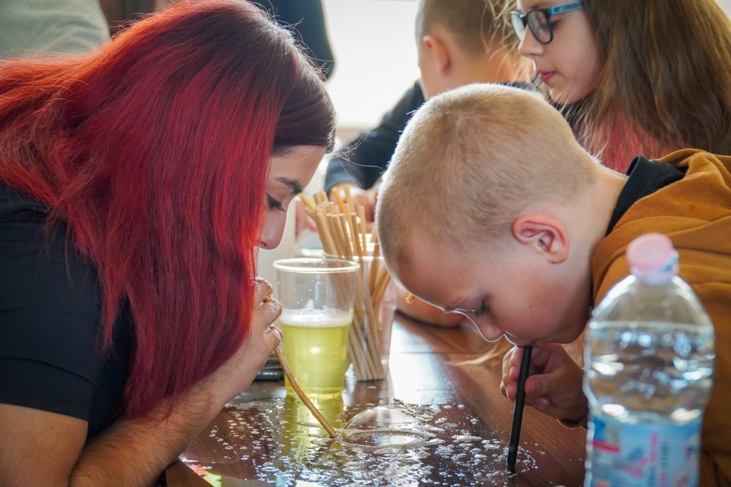 Dzieci piją napój przez słomki na Festiwalu Kreatywności w PANS Jarosław