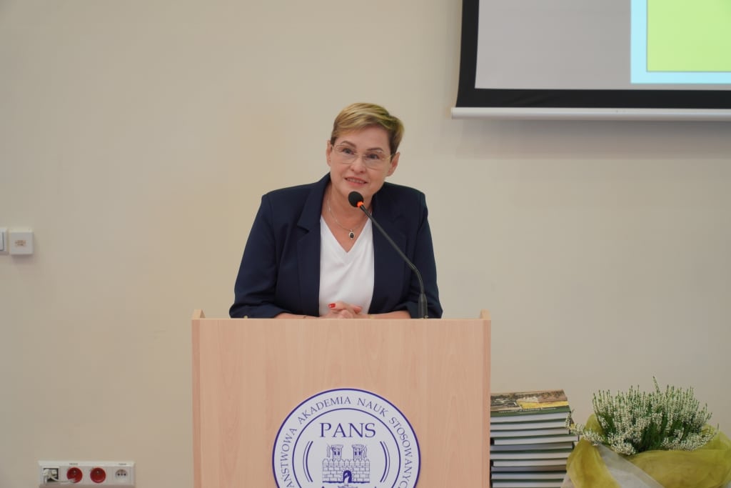 Kobieta przemawia przy mównicy podczas spotkania promującego książkę „Garnizon wojskowy w Jarosławiu”