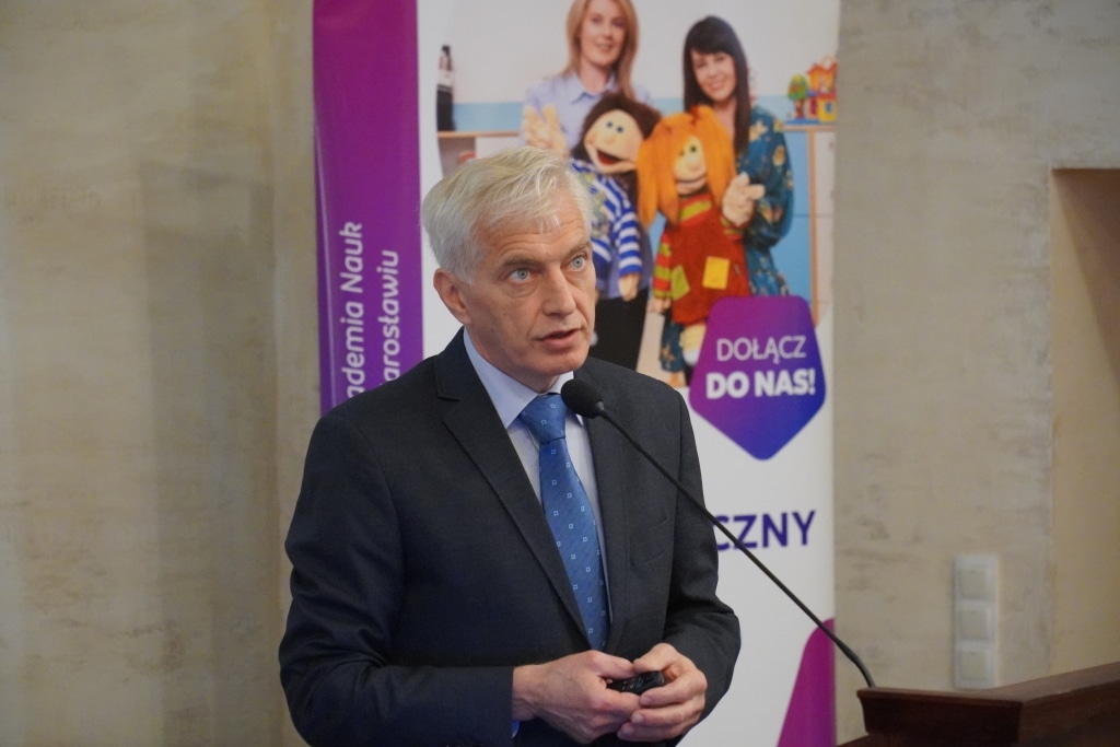 Mężczyzna w garniturze przemawia na konferencji dla dyrektorów szkół