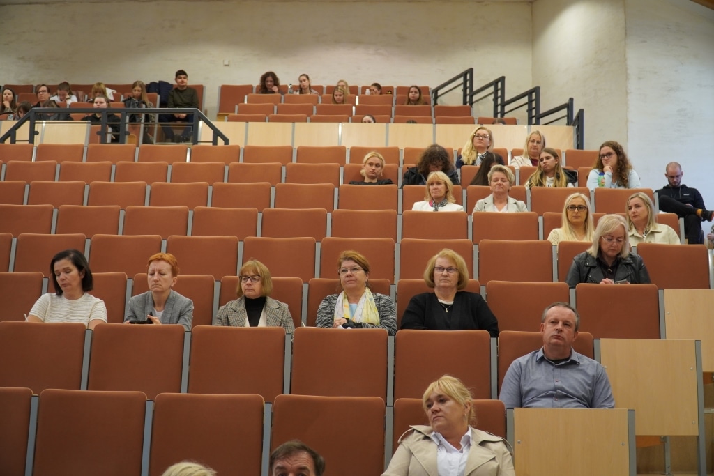 Uczestnicy konferencji dla dyrektorów szkół i placówek oświatowych siedzą na widowni.