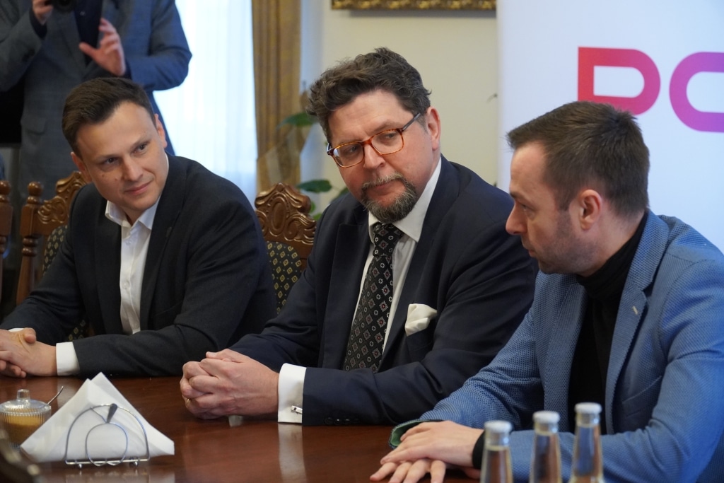 Spotkanie z prof. Andrzejem Szeptyckim i innymi mężczyznami przy stole.