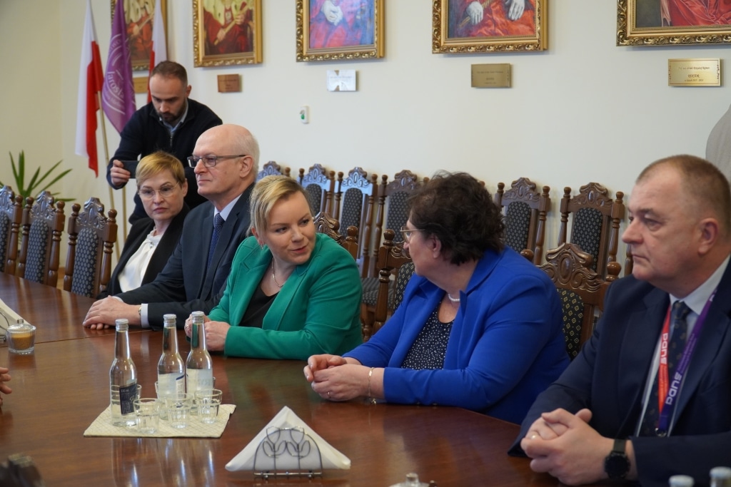 Spotkanie z prof. Andrzejem Szeptyckim - ludzie siedzą przy stole.