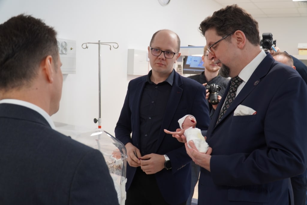 Prof. Andrzej Szeptycki z noworodkiem w inkubatorze podczas spotkania