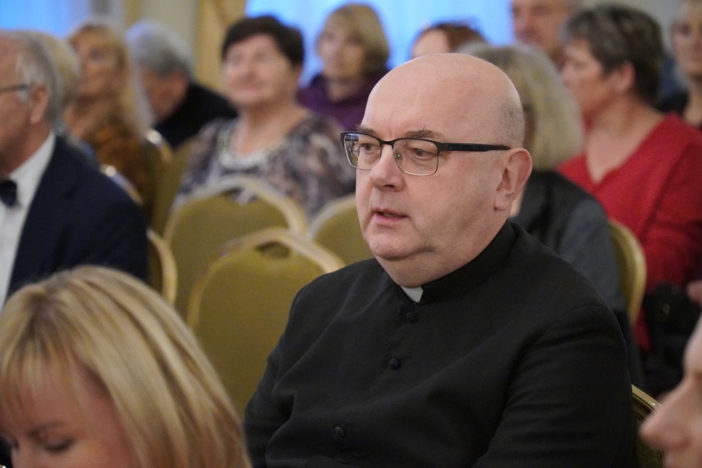 Duchowny w czarnym stroju podczas inauguracji roku akademickiego Akademii Trzeciego Wieku.