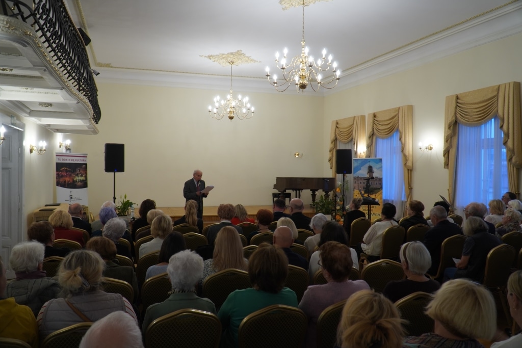 Uroczystość inauguracji roku akademickiego Akademii Trzeciego Wieku w sali pełnej gości.