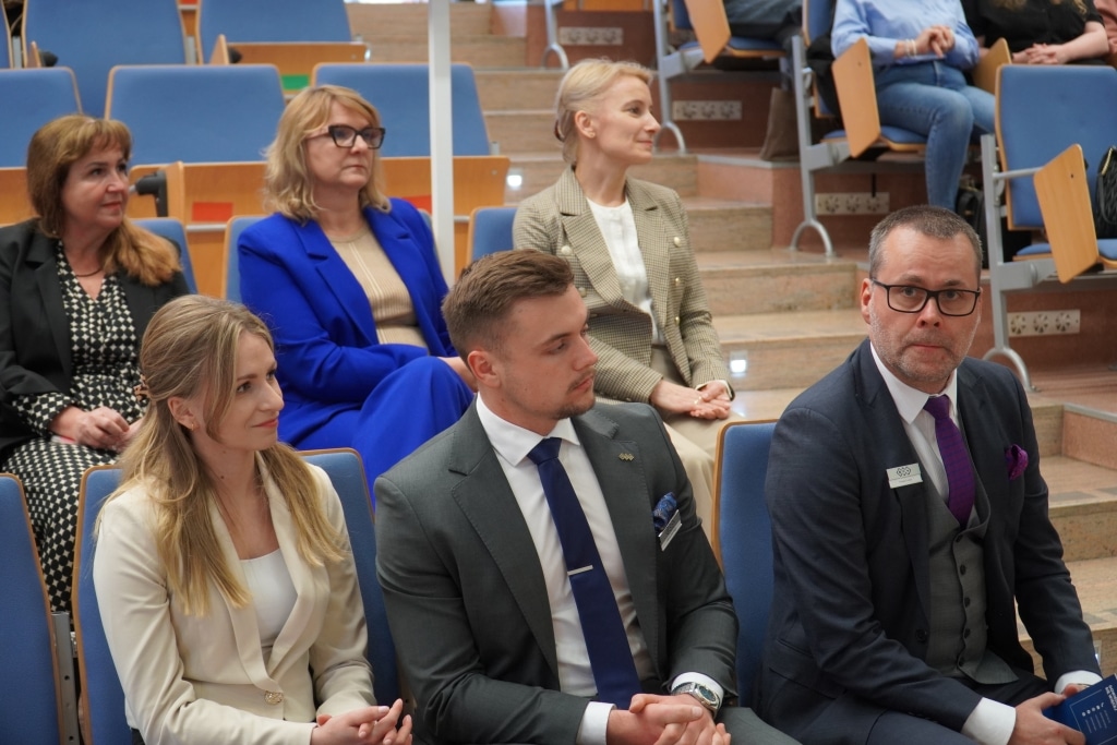 Uczestnicy konferencji naukowej "Aktywność fizyczna a sprawność funkcjonalna" siedzą w audytorium.